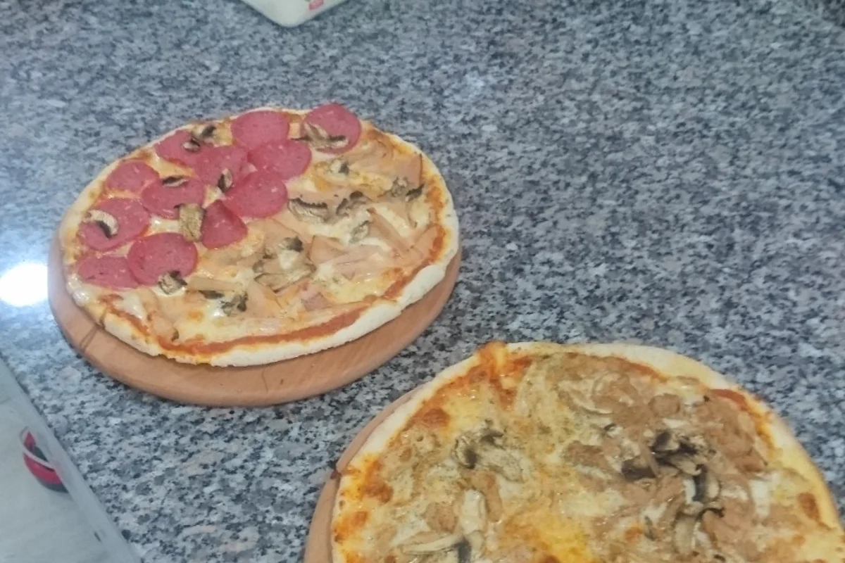 Deux pizzas garnies au fromage, viande et champignons