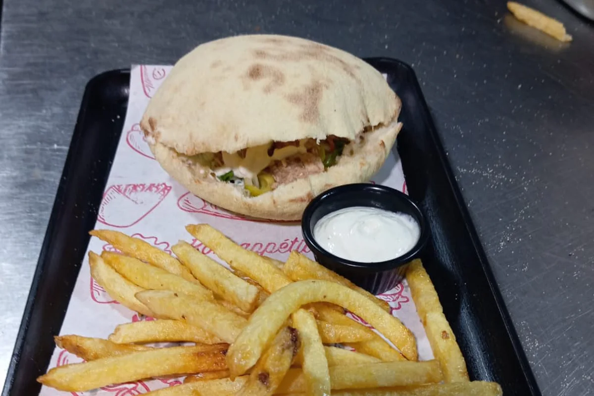 Khbizza ronde garnie servie avec des frites